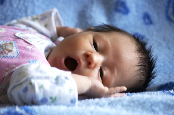 Das kleine schöne Baby, das auf einer Decke liegt — Stockfoto