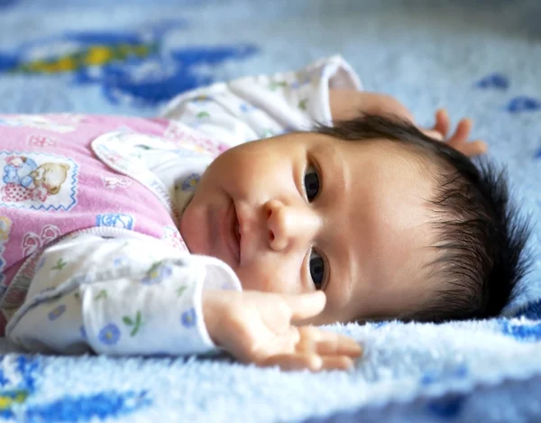 Маленький красивый ребенок лежит на одеяле — стоковое фото