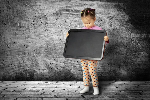 A pequena criança com uma tábua de desenho — Fotografia de Stock