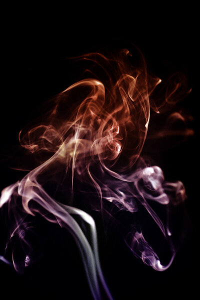 View of some abstract form of colored smoke art isolated on a black background.