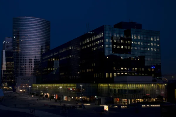 Edifici illuminati di notte in una città — Foto Stock