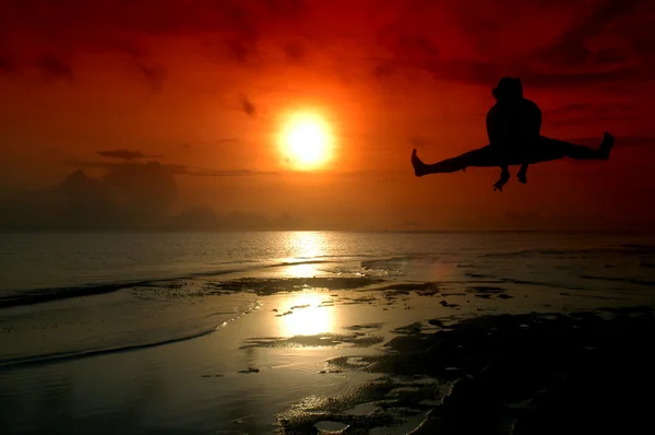 Silueta de un hombre saltando con baground de amanecer — Foto de Stock