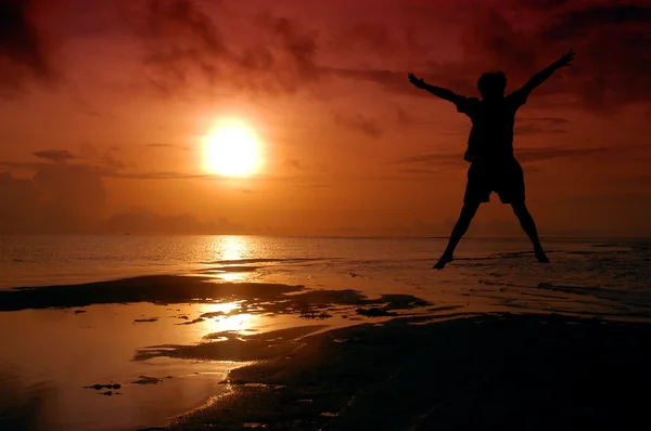 Güneşin içine atlama bir adam silüeti — Stok fotoğraf