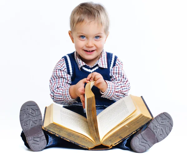 Joli petit garçon assis avec un livre. Dans le studio — Photo