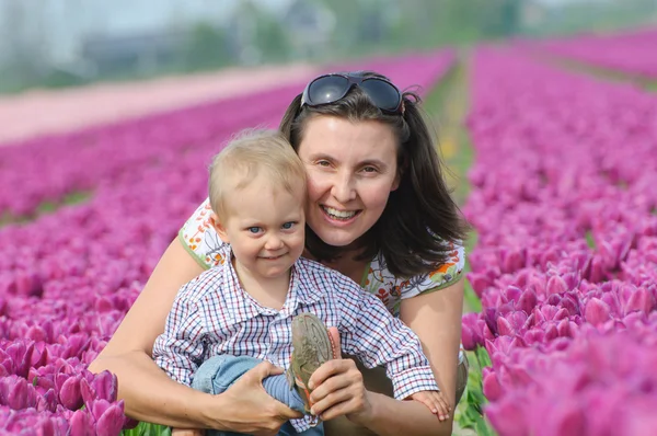 Em Tulip Field. Mãe com filho no campo de tulipas — Fotografia de Stock