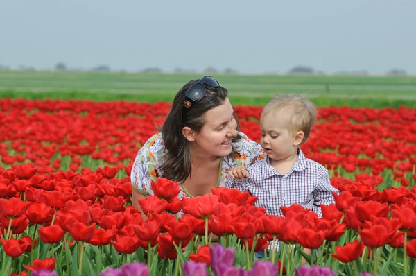 I tulpan område. mamma med son i tulpaner fältet — Stockfoto