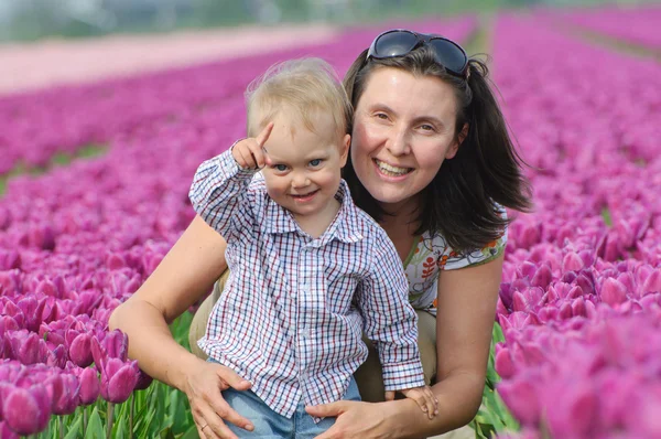 In Tulip Field. Mother with son in tulips field Stock Image