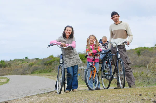 Une famille avec des enfants sur leurs vélos — Photo