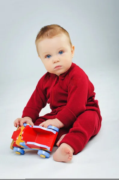 Baby jongen plaing zijn speelgoedauto — Stockfoto