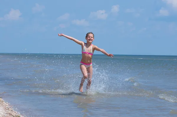 Feliz menina bonita correndo na praia — Fotografia de Stock