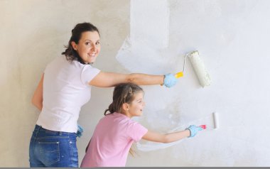 Happy Mother and douther painting a wall with roller clipart