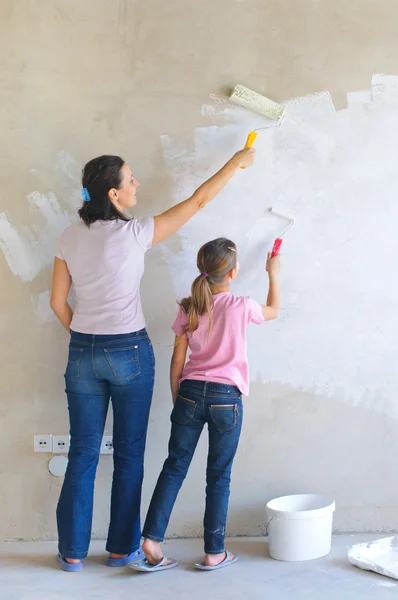 Mãe e douther pintando uma parede com rolo — Fotografia de Stock