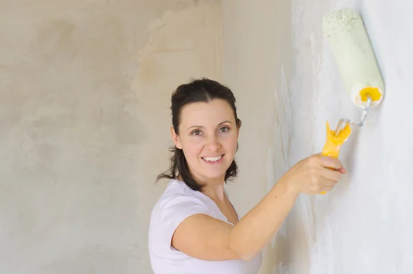 Giovane donna pittura un muro — Foto Stock