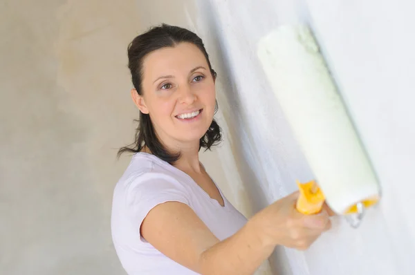 Duvarı boyayan genç bir kadın — Stok fotoğraf
