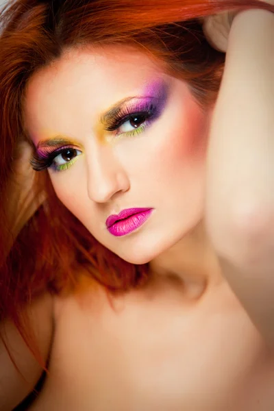 Porträtt av sexiga kvinna med mångfärgade make-up och långa röda hår — Stockfoto