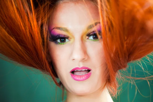 Mooi meisje met veelkleurige make-up en rode lange haren — Stockfoto