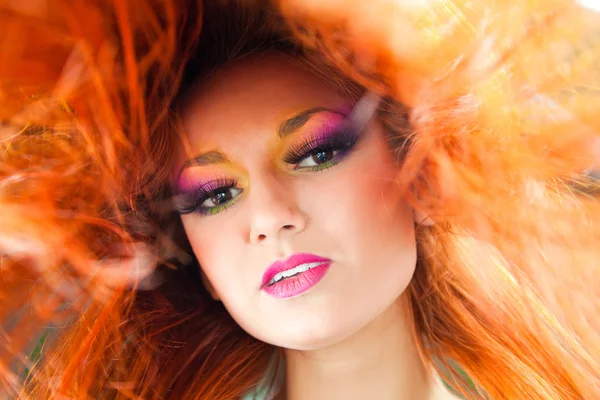 Belle fille avec maquillage multicolore et cheveux longs rouges — Photo