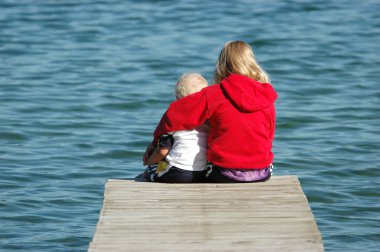 Sister and Brother Sitting on Dock clipart