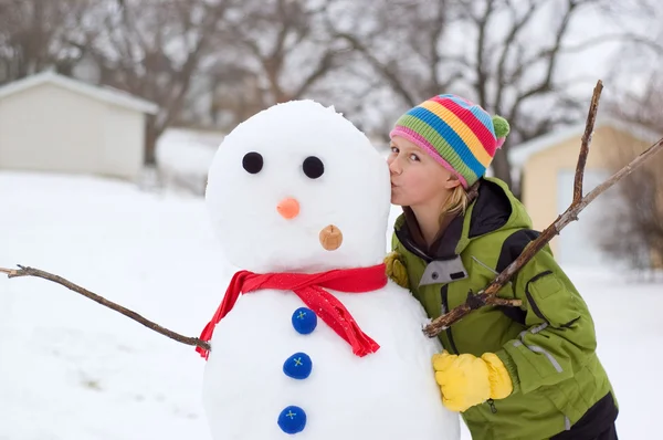 Cute Young Girl Kisses Snowman — Stock Photo, Image