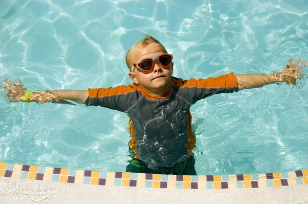 プールの端の近くで浮いて少年ゴーグル — ストック写真