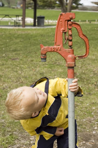küçük bir çocuk ve su pompası