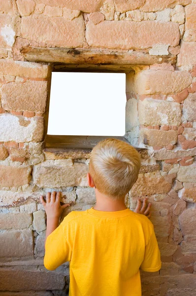 Rapaz olha através da janela — Fotografia de Stock