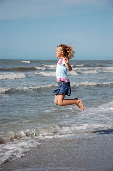 Jong meisje springt in de branding — Stockfoto