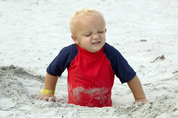 砂で遊ぶ小さな男の子 ロイヤリティフリーのストック写真
