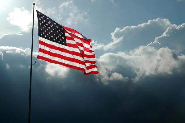 Bandiera americana contro i cieli tempestosi Foto Stock