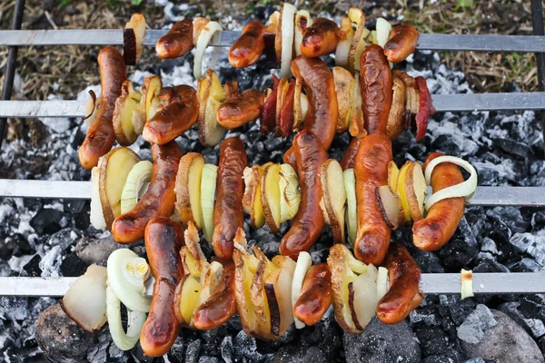 Sausages and bacon on skewers — Stock Photo, Image
