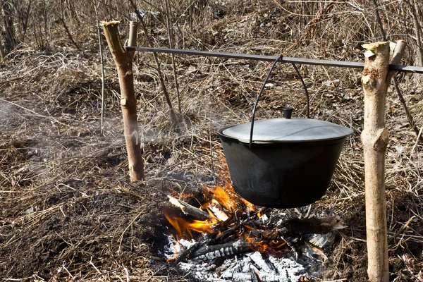 Preparing food on campfire Stock Picture