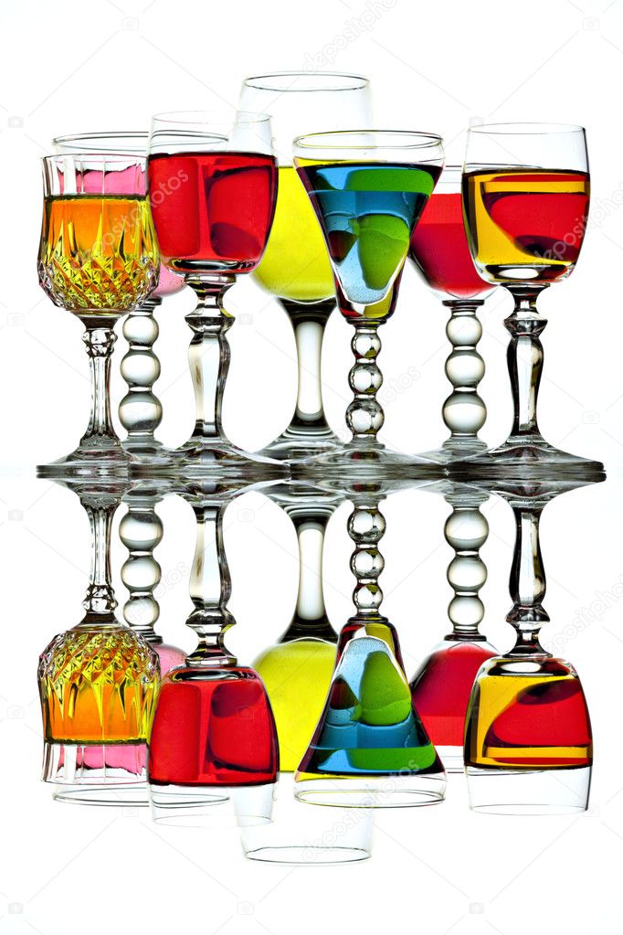 Seven colorful wine glasses with reflection