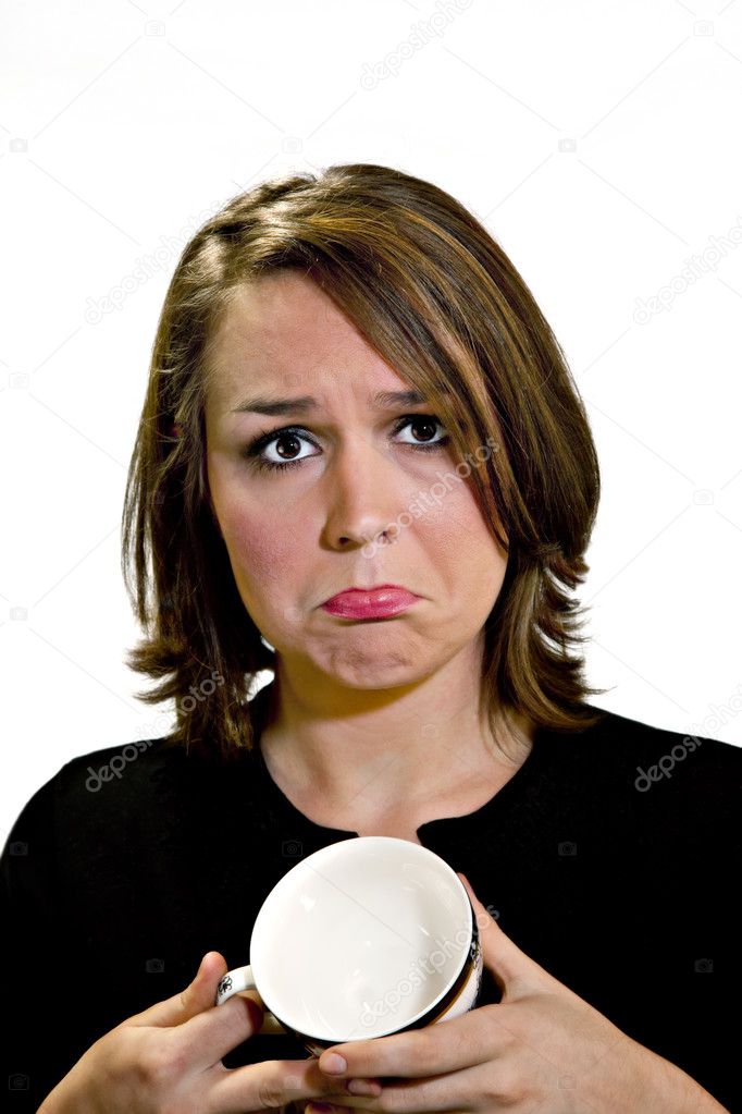 Beautiful brunette with sad face and empty coffee cup