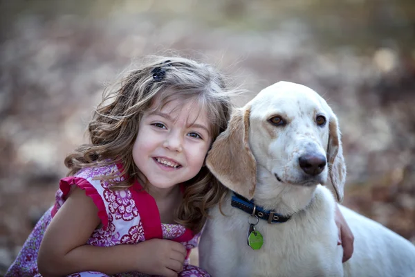 Aranyos kislány cuddling fehér kutya — Stock Fotó