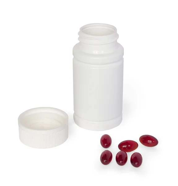 stock image White medicine bottle with brown pills scattered