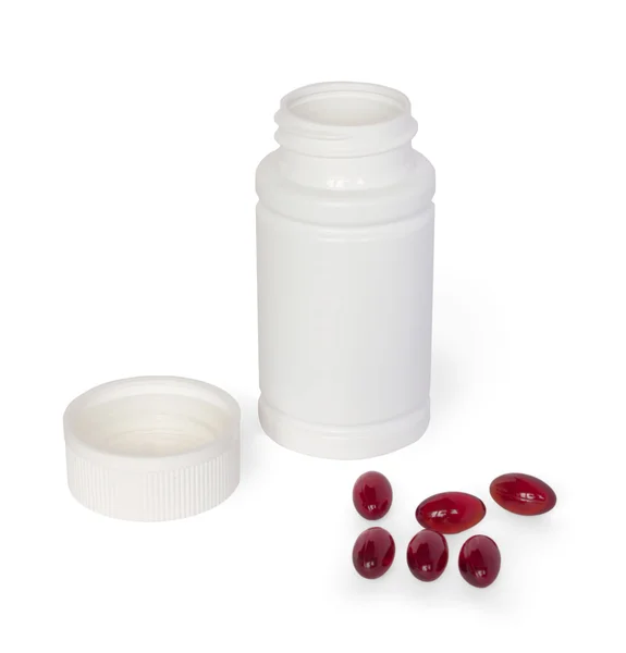 Пляшка білої медицини з розкиданими коричневими таблетками Стокове Фото