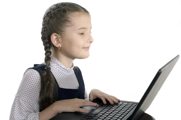Menina senta-se no computador no fundo branco — Fotografia de Stock