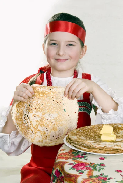 Flickan har kontroll över en pannkaka — Stockfoto