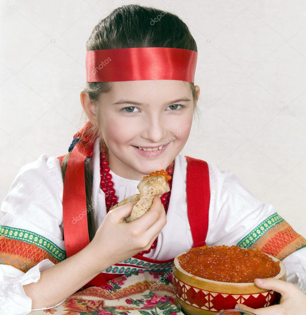 Russian girl with caviar and a pancake in a hand.