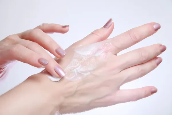 Mujer aplicando cremas cosméticas hidratantes en sus manos —  Fotos de Stock
