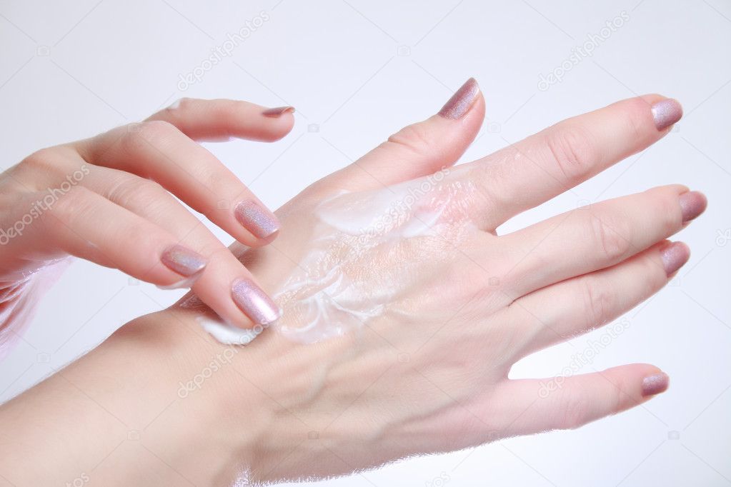 Woman applying moisturizing cosmetic creams on her hands