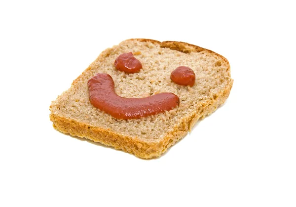 stock image Smiley face on a piece of black bread