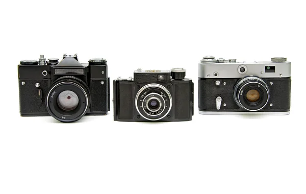 Beyaz zemin üzerinde üç eski analog fotoğraf makinesi — Stok fotoğraf