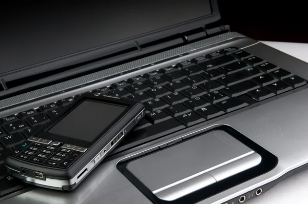 Telefon na laptopie — Zdjęcie stockowe