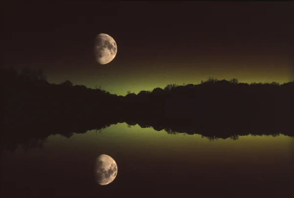 Αντανάκλαση φεγγάρι πάνω από το εμφιαλωμένο νερό Royalty Free Φωτογραφίες Αρχείου