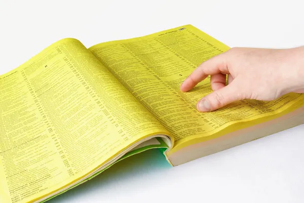 Insan eli ve sarı sayfalar — Stok fotoğraf
