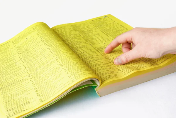 Menselijke hand en gele pagina 's Stockafbeelding