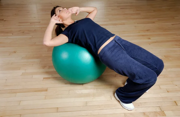 Kobieta robi siedzieć ups z swiss ball — Zdjęcie stockowe