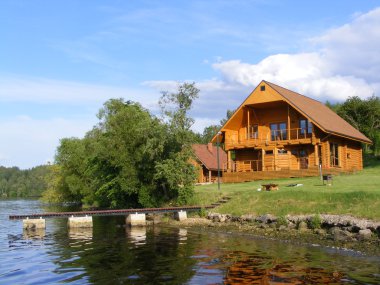 Beautiful wooden house near the river clipart