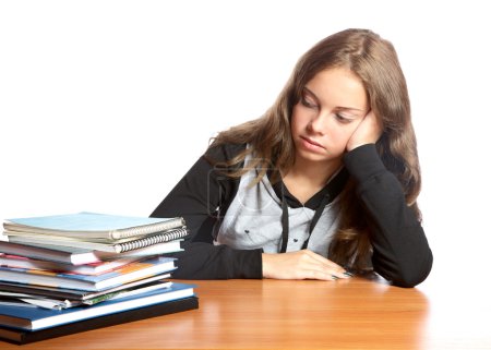 La fille-adolescente regarde un tas de livres 